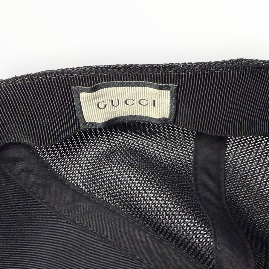 Étiquette intérieure de marque GUCCI sur une casquette noire en maille filet Secondstore