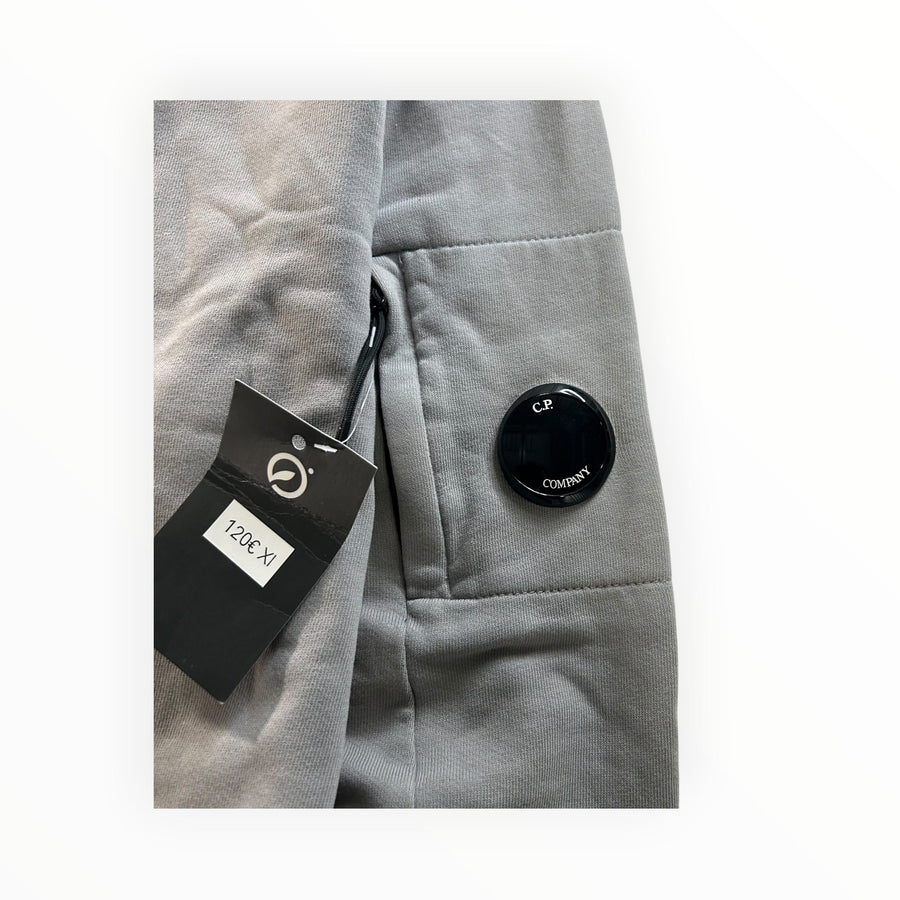 Secondstore C.P. Company grey cotton sweatshirt sleeve featuring the iconic black lens pocket detail and brand tag.