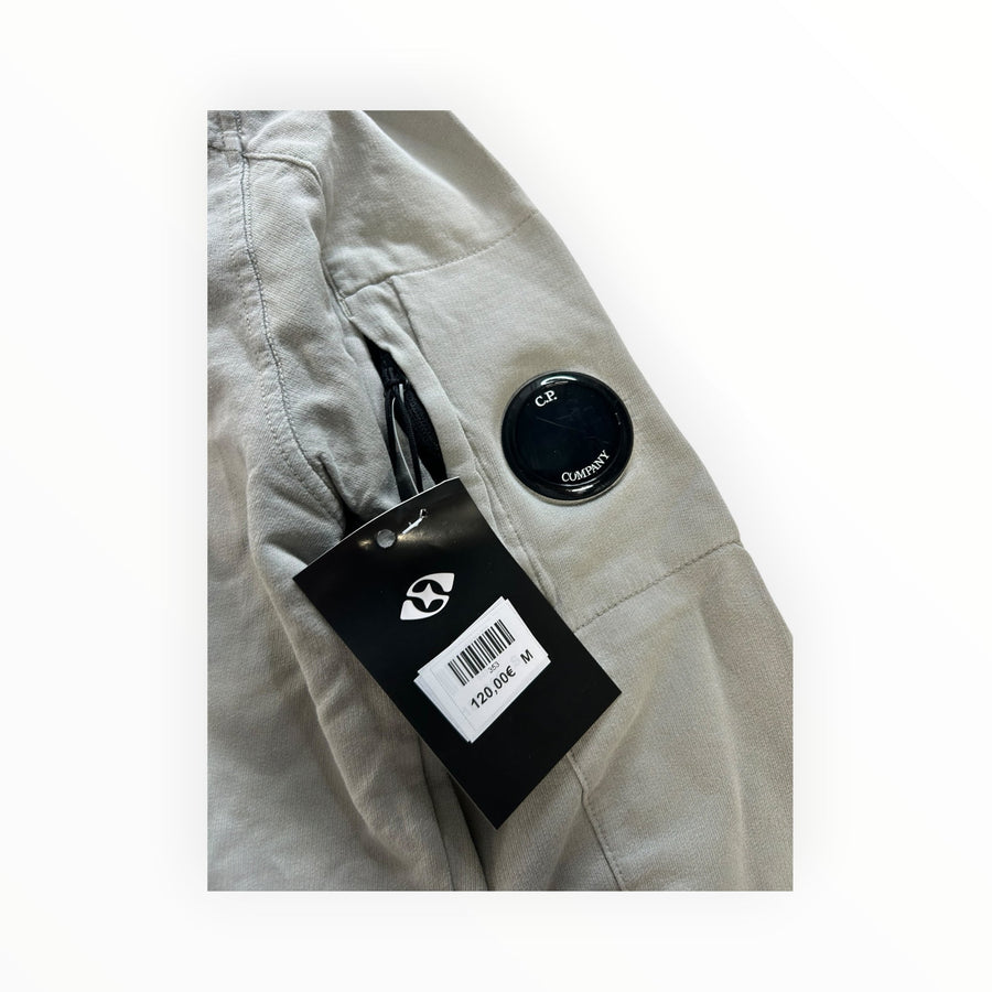 Secondstore C.P. Company sage-grey cotton sweatshirt sleeve with signature lens pocket and attached retail tag