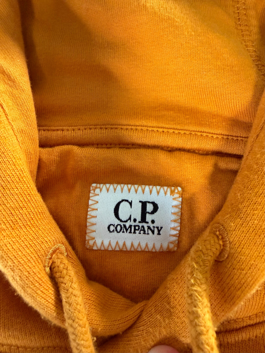 Gros plan sur l'étiquette de marque C.P. Company à l'intérieur d'un sweat à capuche orange Secondstore