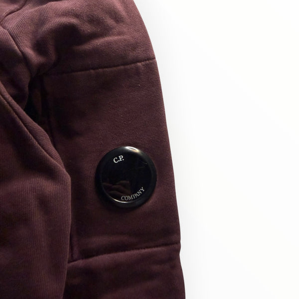 Détail de la manche bordeaux du sweat-shirt Secondstore C.P. Company avec sa lentille emblématique noire