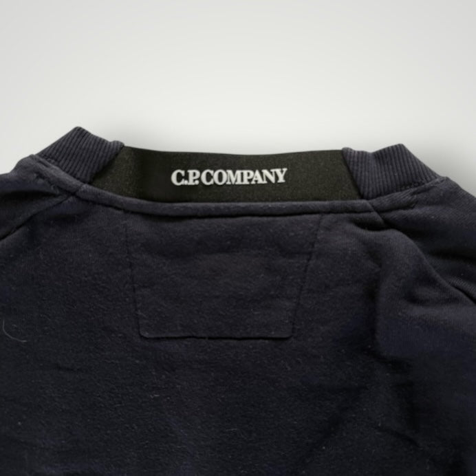 Gros plan sur le col rond noir en coton du sweat-shirt Secondstore C.P. COMPANY avec étiquette de marque visible