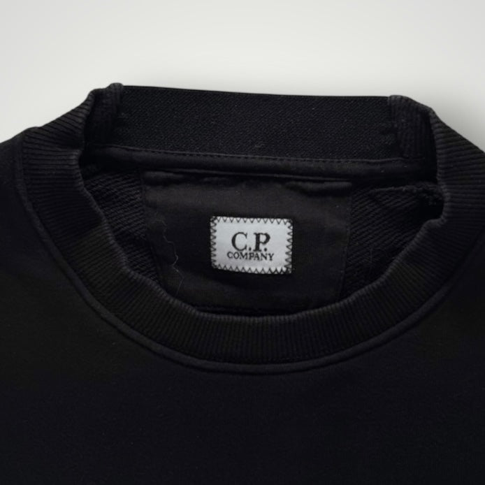 Gros plan sur le col rond noir en coton du sweat-shirt Secondstore C.P. Company avec étiquette de marque cousue