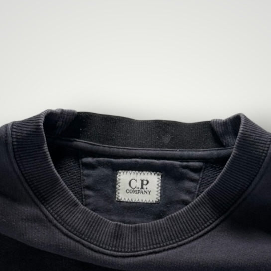 Gros plan sur le col rond en coton noir du sweat-shirt Secondstore C.P. COMPANY avec étiquette de marque visible