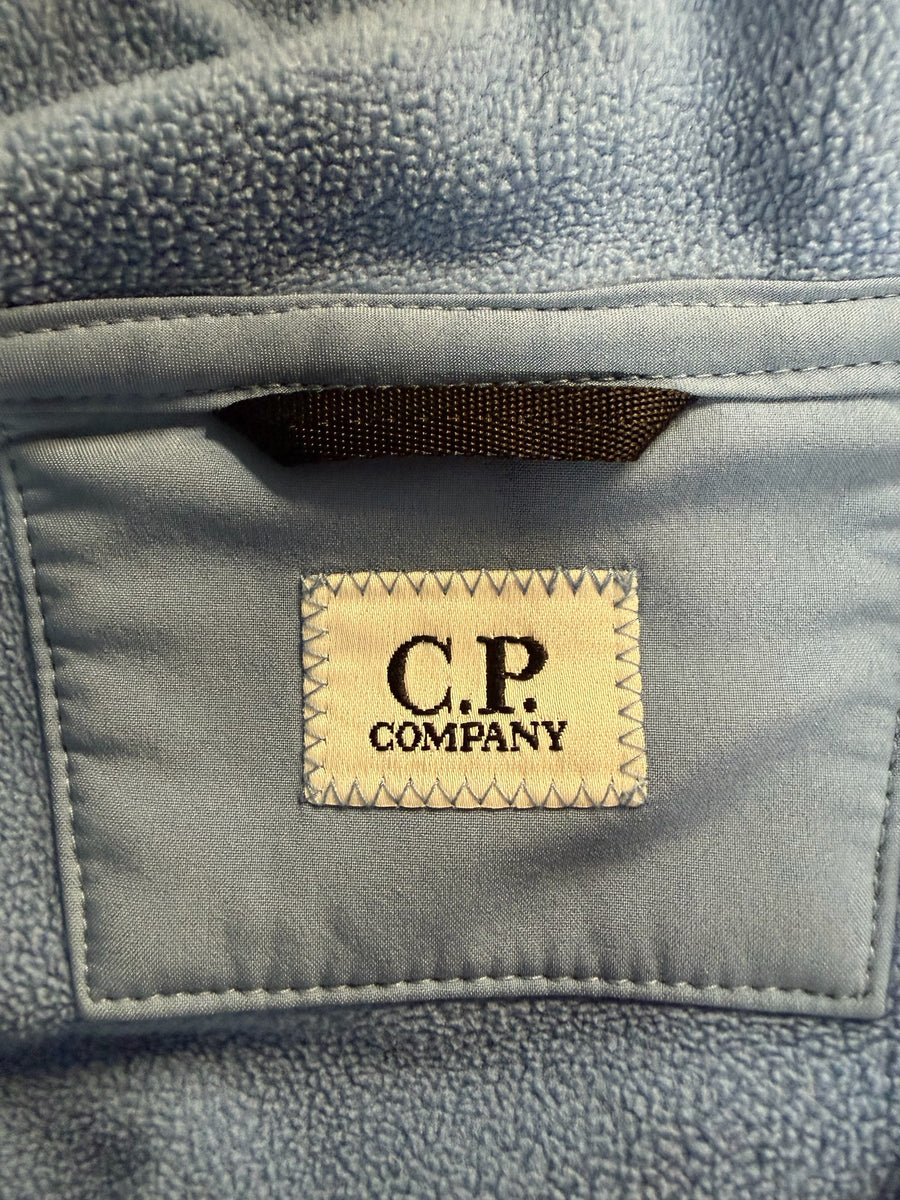 Étiquette de marque C.P. Company cousue sur une doublure en polaire bleue douce d'une veste Secondstore