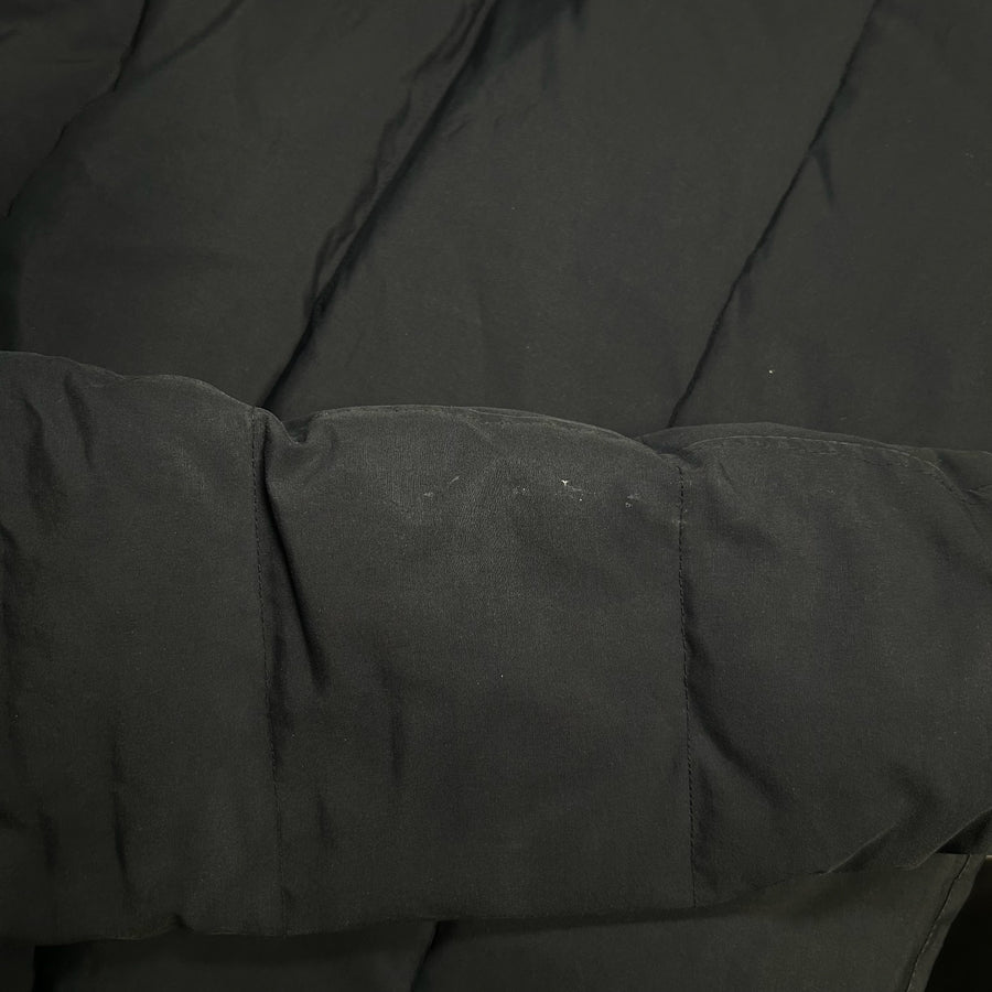 Détail de la manche matelassée noire d'une doudoune Secondstore Canada Goose avec coutures robustes