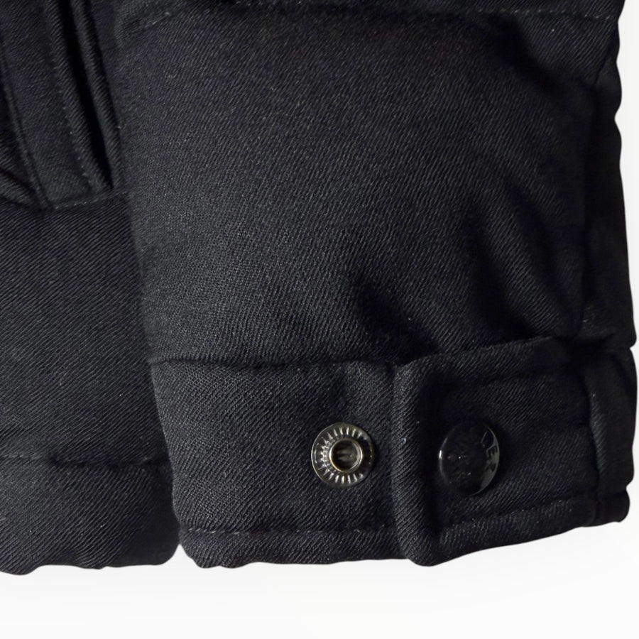 Détail de la manche d'une doudoune noire Secondstore avec poignet ajustable par boutons-pression