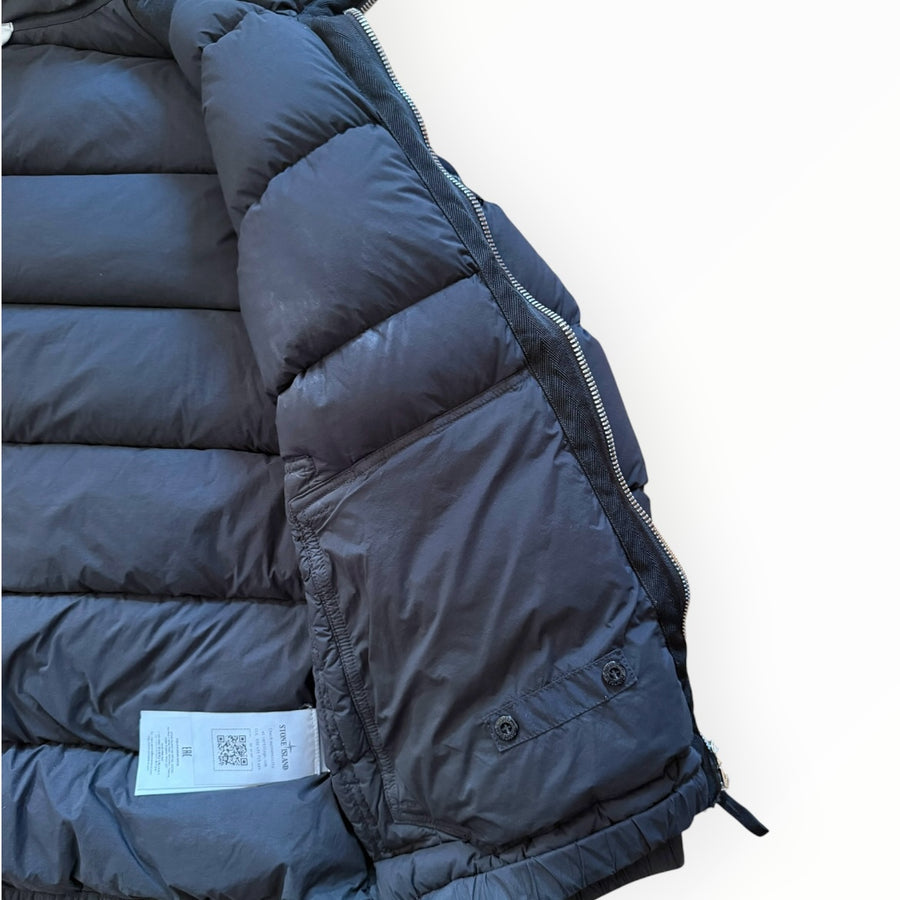 Détail intérieur d'une doudoune Secondstore Stone Island en nylon noir avec étiquette d'authenticité et fermeture