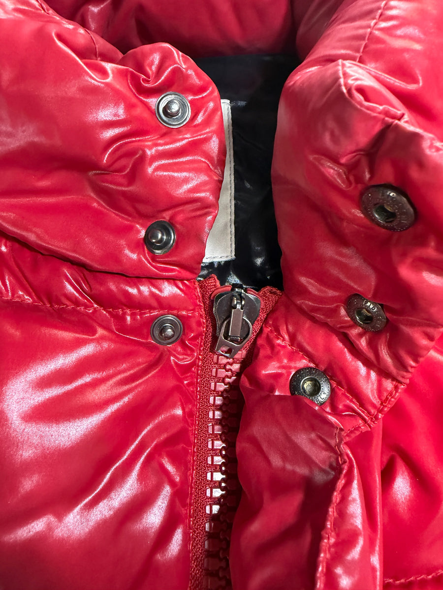 Gros plan sur le gilet sans manches rouge brillant Secondstore Moncler avec fermeture zippée et boutons-pression