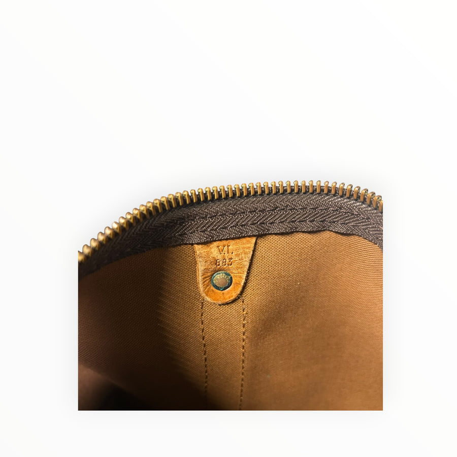 Détail intérieur du sac de voyage Secondstore Louis Vuitton Keepall montrant le code date gravé sur cuir marron
