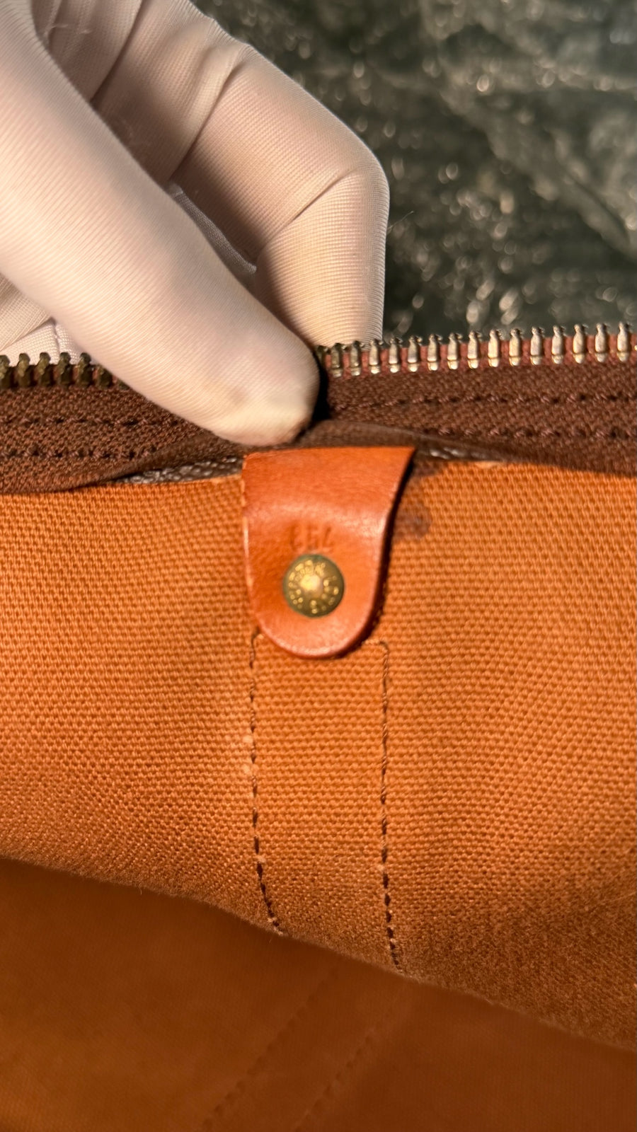 Détail intérieur du sac Secondstore Louis Vuitton Keepall avec doublure en toile marron et bouton pression en laiton