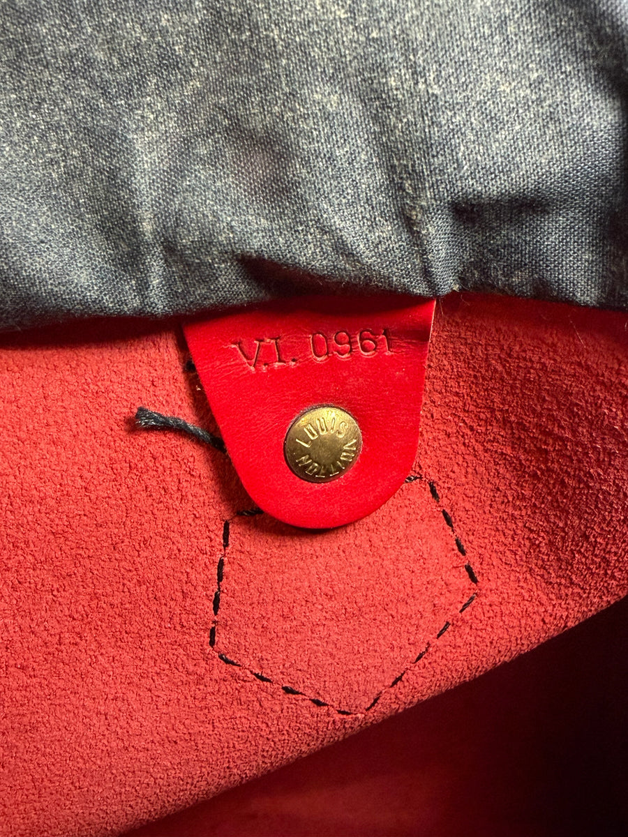 Détail intérieur du sac Secondstore Louis Vuitton Speedy avec bouton pression doré et code date gravé sur cuir rouge