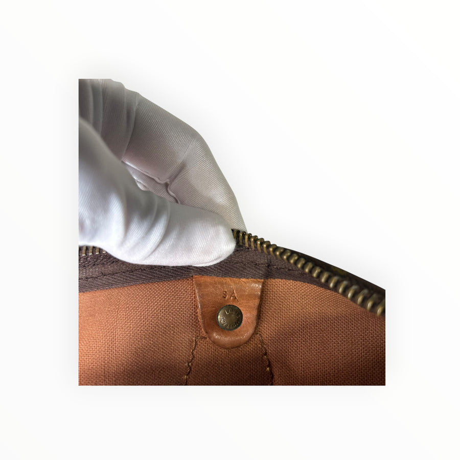 Détail intérieur du sac Secondstore Louis Vuitton Speedy montrant le rivet gravé et la doublure en toile marron