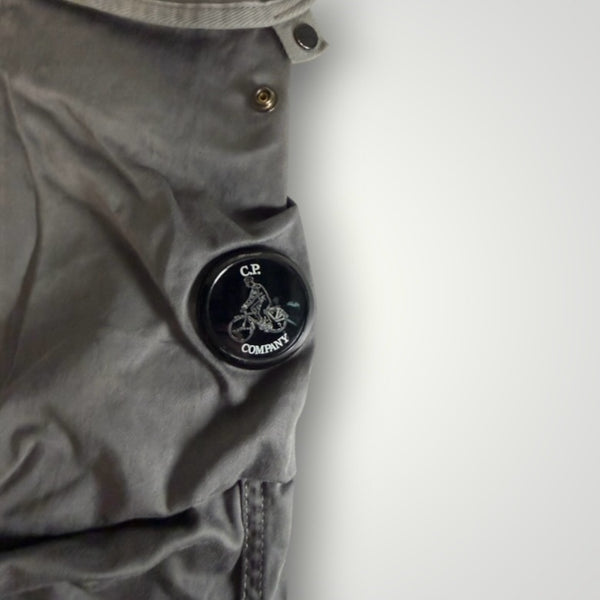 Gros plan sur le badge emblématique C.P. Company sur un pantalon cargo gris en coton de la boutique Secondstore