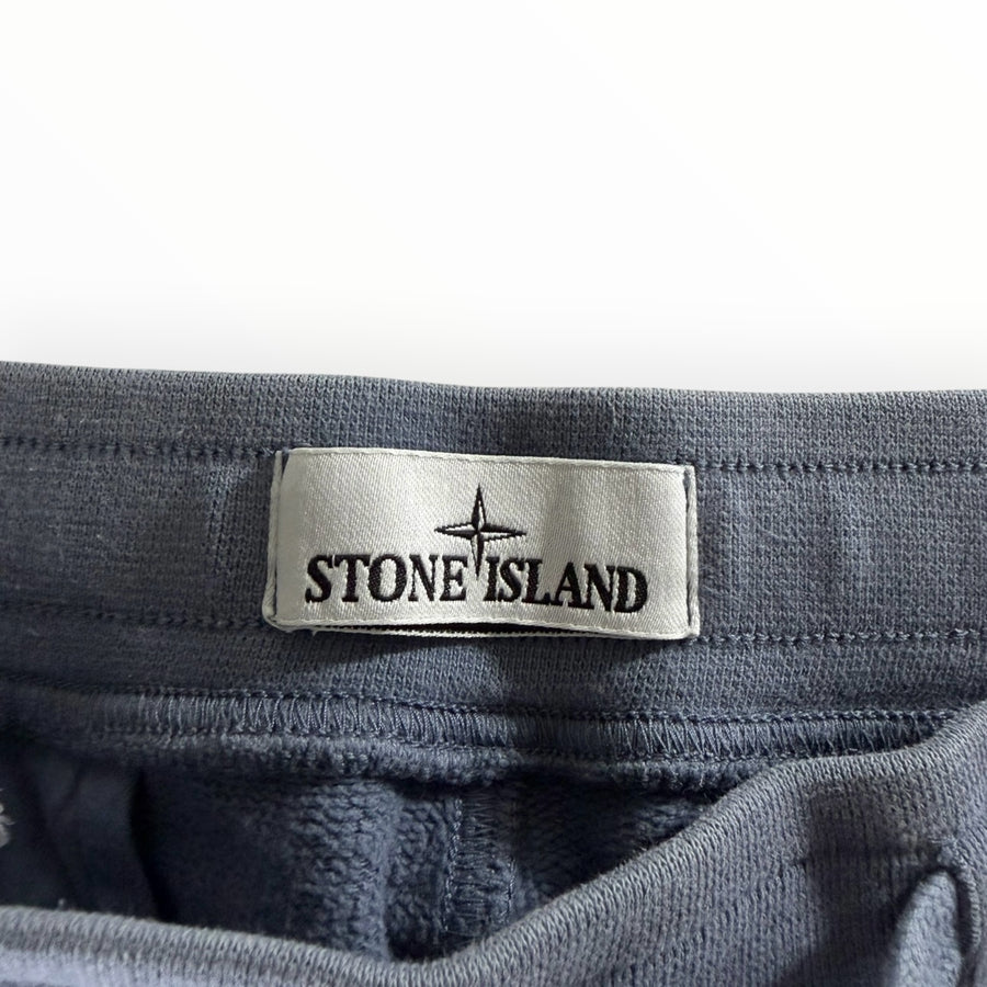 Gros plan sur l'étiquette logo Stone Island cousue sur la taille élastique d'un pantalon de jogging Secondstore gris