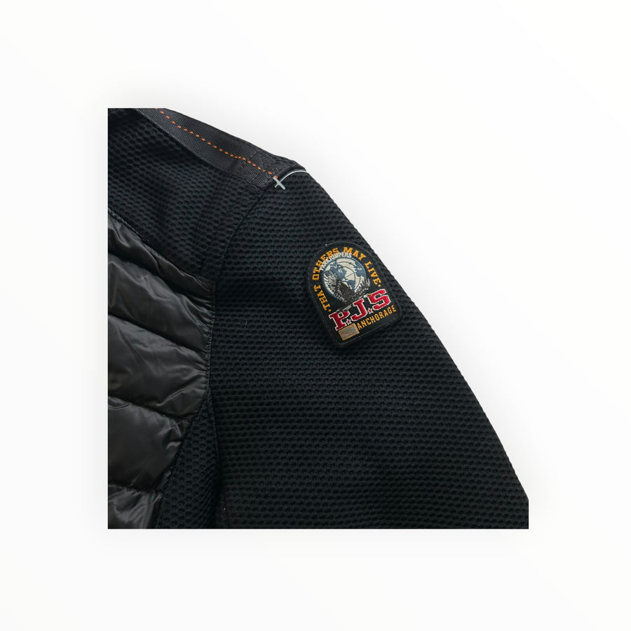 Détail de la manche et de l'épaule de la veste hybride noire Secondstore Parajumpers avec écusson PJS brodé