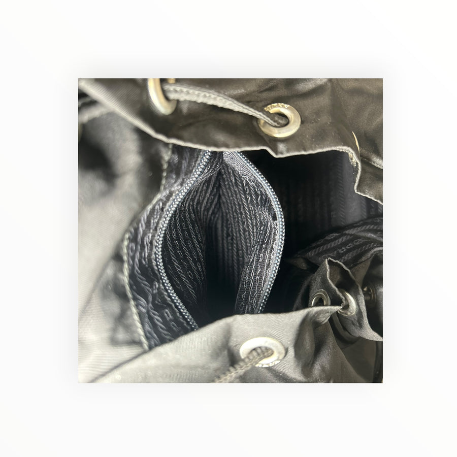 Détail de la poche intérieure zippée du sac à dos Secondstore Prada en nylon noir avec doublure jacquard signature
