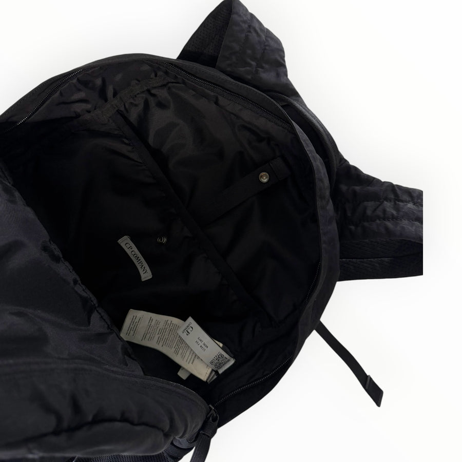 Intérieur du sac à dos noir en nylon Secondstore C.P. Company avec étiquette de marque et compartiments zippés