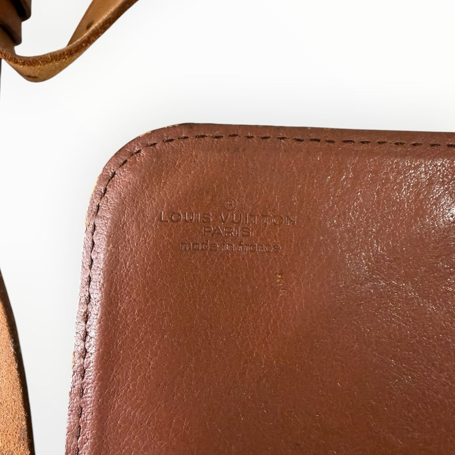 Détail du logo embossé Louis Vuitton sur le cuir marron d'un sac bandoulière vintage chez Secondstore