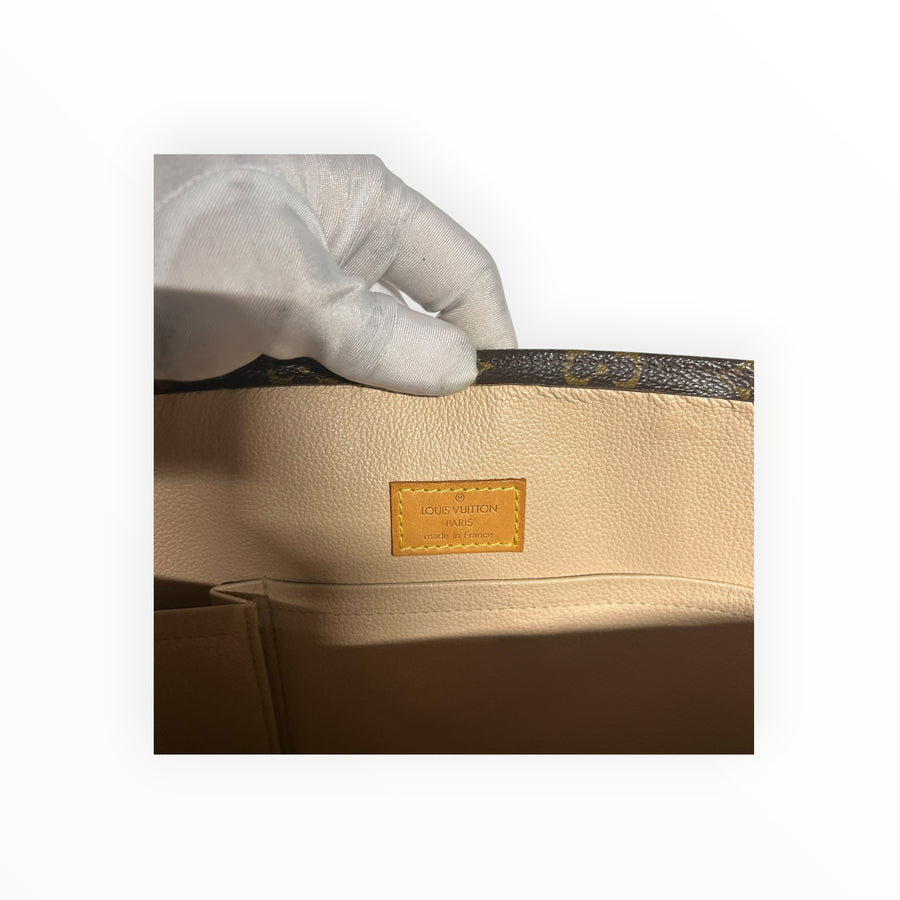 Intérieur du sac cabas Secondstore Louis Vuitton avec étiquette en cuir embossée et doublure beige