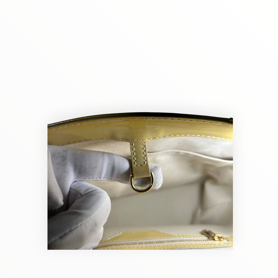 Détail intérieur du sac cabas Secondstore Louis Vuitton en cuir verni jaune pâle avec attache en métal doré