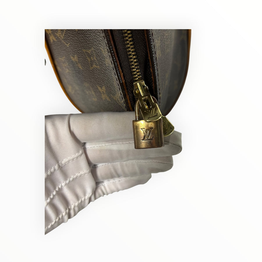 Détail du cadenas doré gravé sur le sac Louis Vuitton Ellipse en toile Monogram marron chez Secondstore