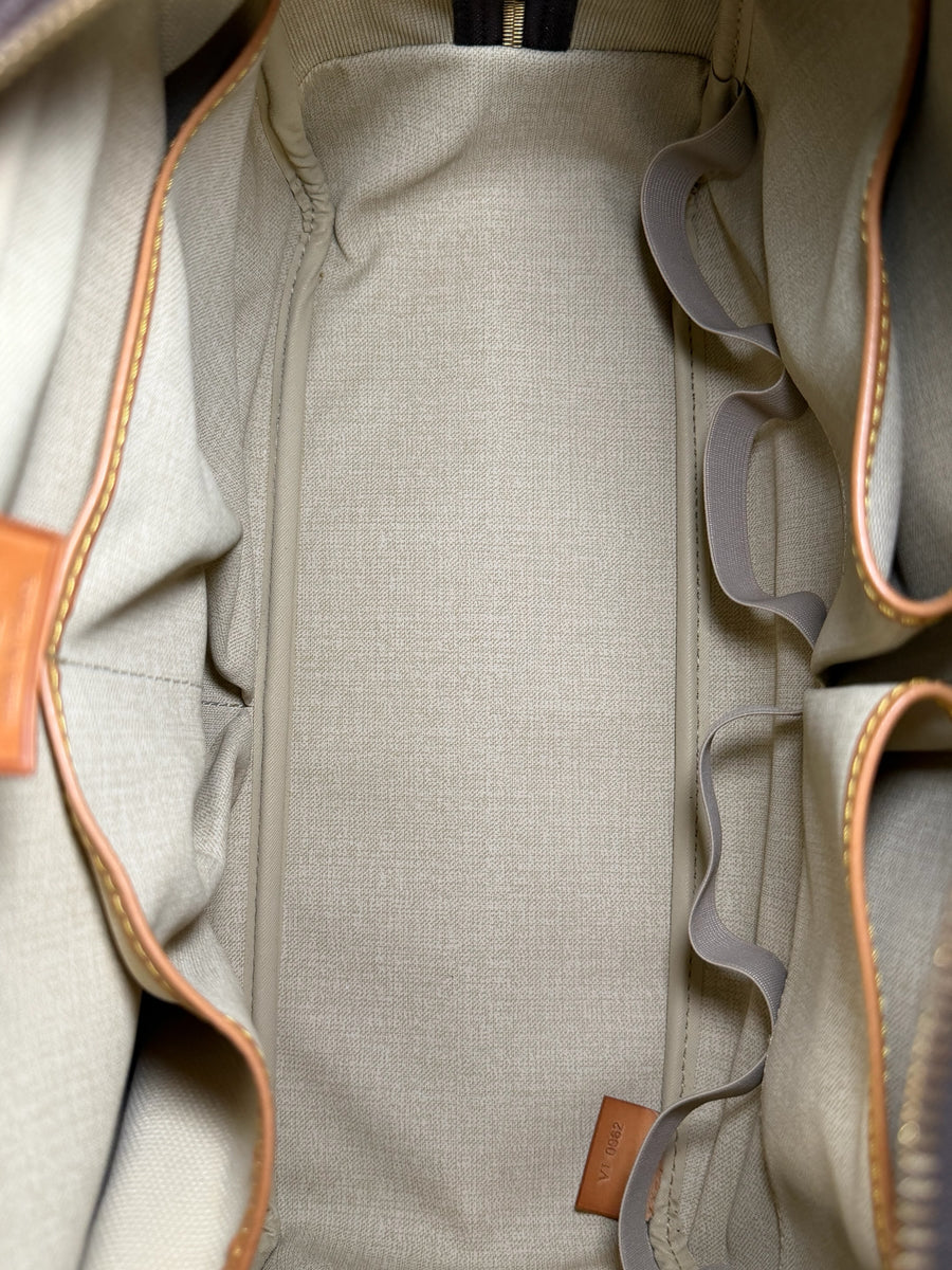 Intérieur spacieux et doublé en textile beige du sac de voyage Secondstore Louis Vuitton avec compartiments