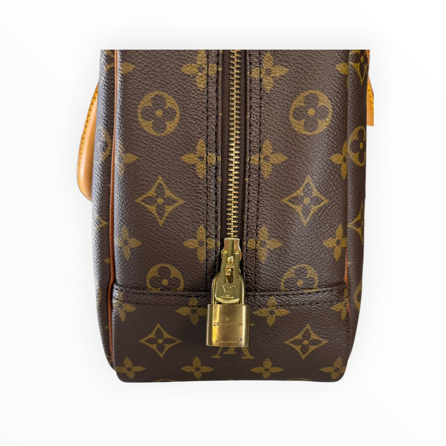 Détail du cadenas doré sur un sac de voyage Secondstore Louis Vuitton en toile Monogram et cuir naturel