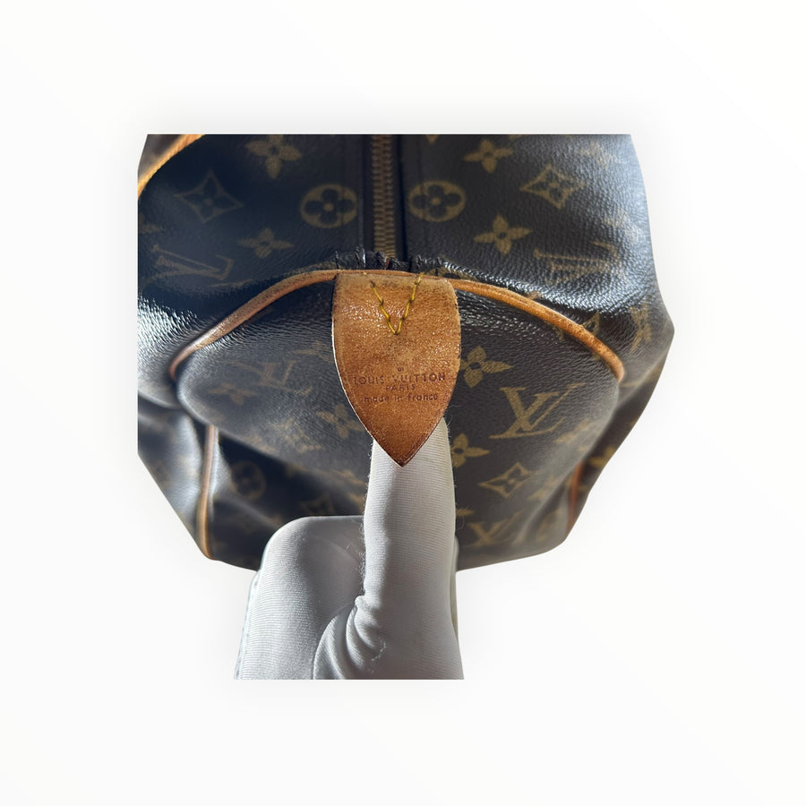 Détail du logo Louis Vuitton sur cuir de vachette d'un sac de voyage Secondstore en toile Monogram marron