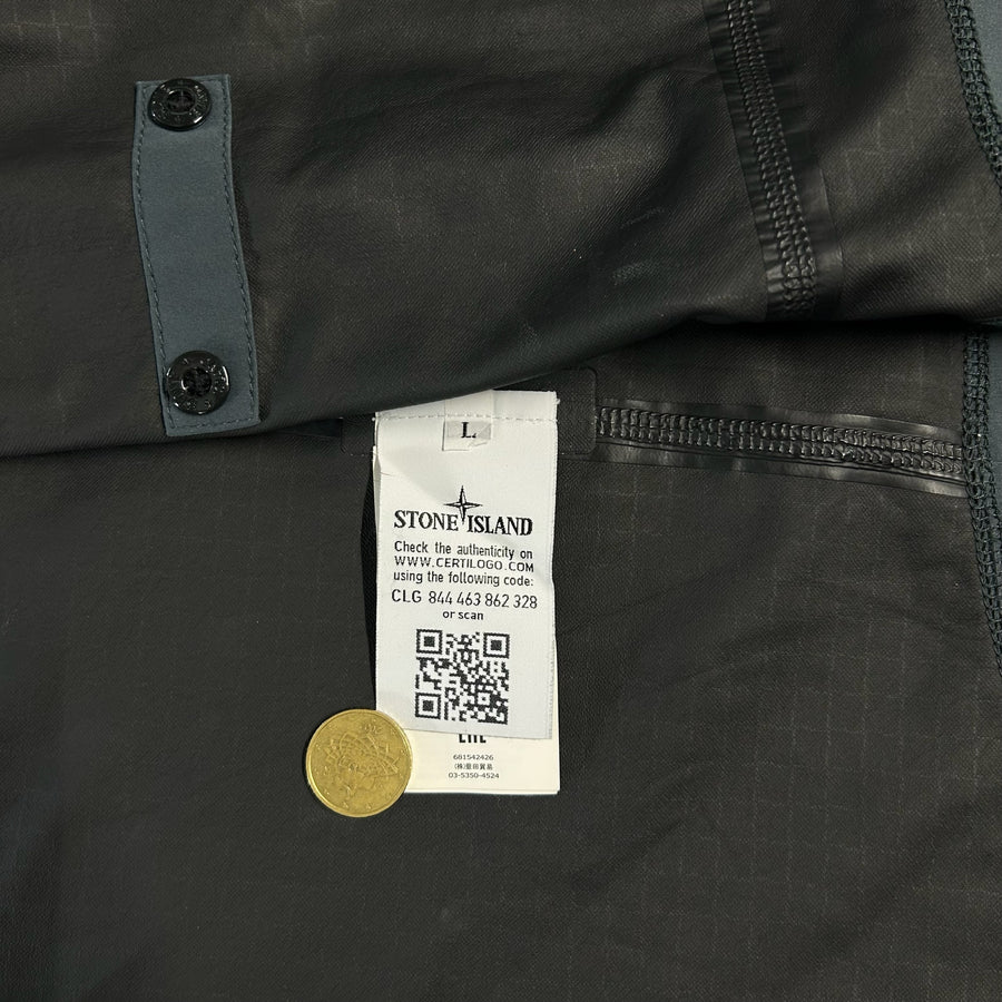 Secondstore Stone Island jacket interior showing the authentic Certilogo label, size L tag, and check grid fabric.