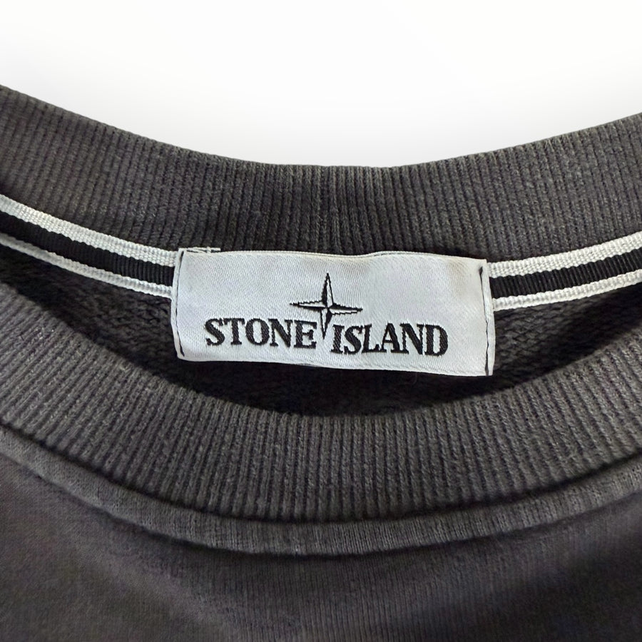 Gros plan sur l'étiquette de col d'un sweat-shirt gris anthracite Secondstore Stone Island en coton côtelé