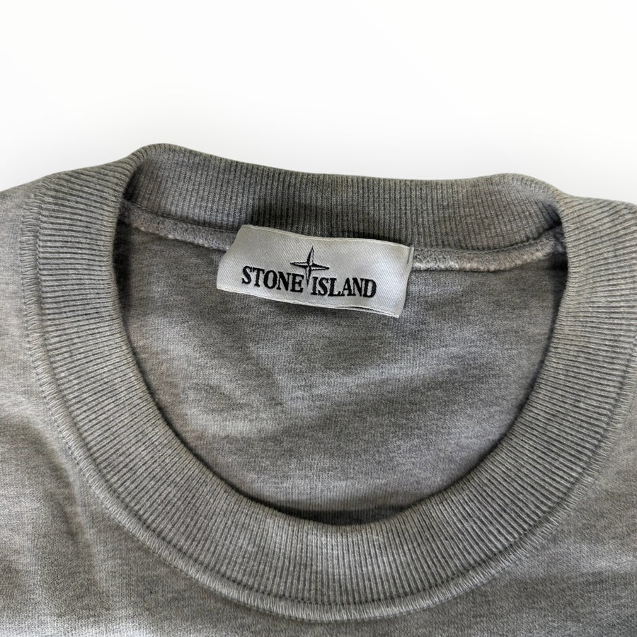Gros plan sur le col rond en coton gris chiné d'un sweat-shirt Secondstore Stone Island avec étiquette de marque