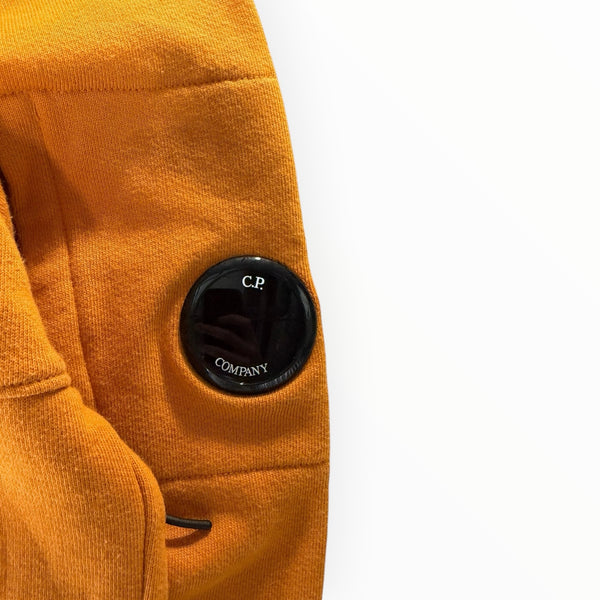Détail de la lentille noire emblématique sur la manche d'un sweat à capuche orange Secondstore en coton