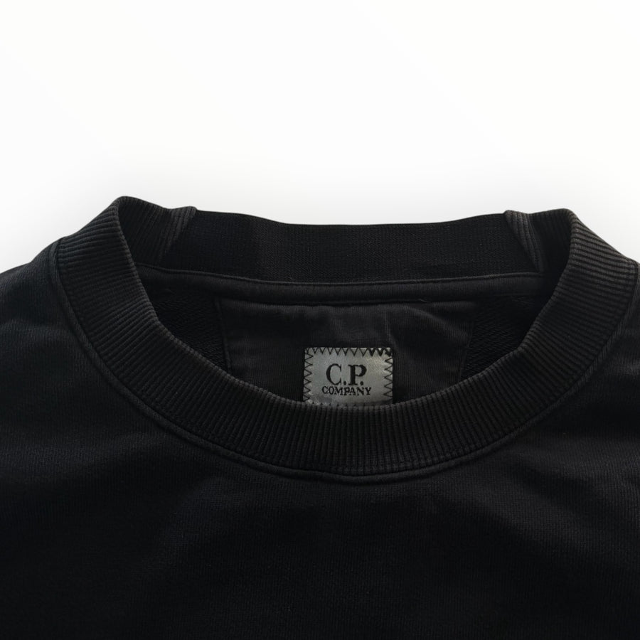 Gros plan sur le col rond noir en coton du sweat-shirt Secondstore C.P. Company avec étiquette de marque cousue