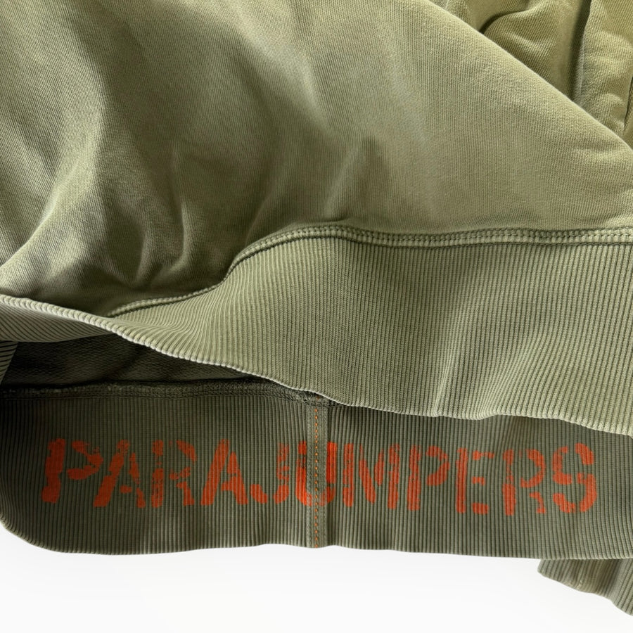Détail de l'ourlet côtelé vert olive d'un sweat-shirt Secondstore Parajumpers avec logo orange imprimé à l'intérieur