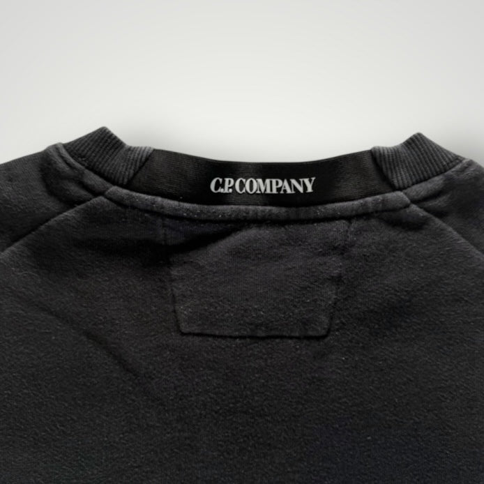 Détail du col rond noir en coton avec étiquette de marque Secondstore C.P. COMPANY visible à l'intérieur