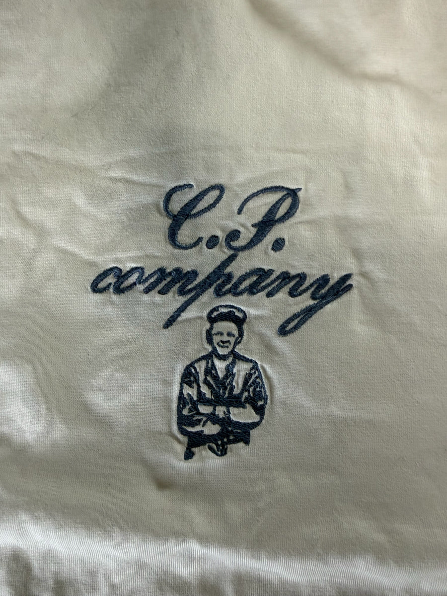 Gros plan sur la broderie logo marine sur t-shirt beige en coton mercerisé Secondstore