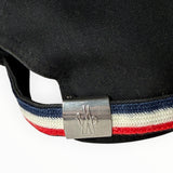 Détail de la sangle arrière Secondstore d'une casquette Moncler noire avec boucle métallique gravée et bande tricolore