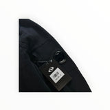 Secondstore C.P. Company black cotton sweatshirt sleeve featuring the iconic signature lens detail and brand tag