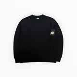 Secondstore black C.P. Company crewneck sweatshirt featuring a signature lens detail on the utility sleeve pocket.