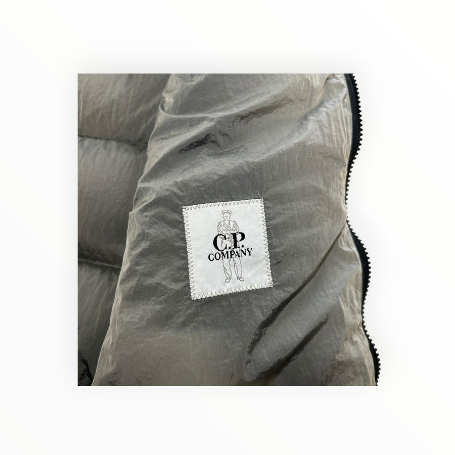 Détail de l'étiquette de marque C.P. Company sur une doudoune sans manches Secondstore en nylon irisé gris