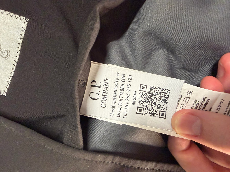 Étiquette d'authenticité avec code QR et logo C.P. Company à l'intérieur d'une veste Secondstore