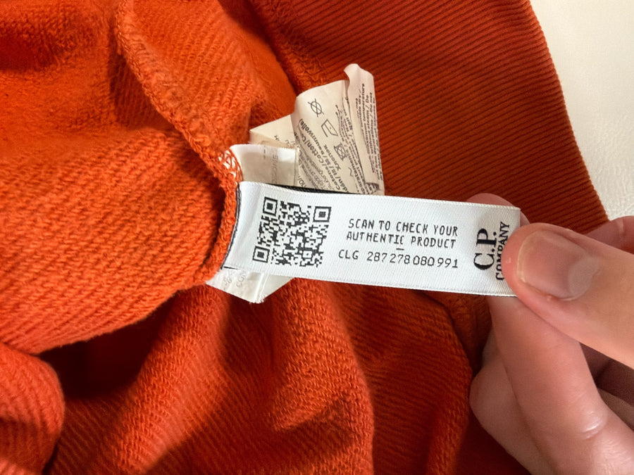 Étiquette d'authenticité avec code QR et numéro CLG à l'intérieur d'un sweat-shirt orange Secondstore C.P. Company
