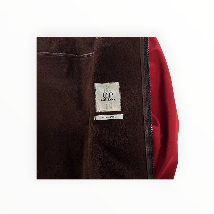 Interior of a red Secondstore C.P. Company Goggle Jacket showing the fleece lining and brand label