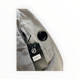 Secondstore C.P. Company grey cotton sweatshirt featuring the iconic lens detail on a sleeve pocket with a price tag.