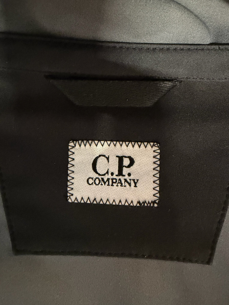 Gros plan sur l'étiquette logo C.P. Company cousue sur la doublure noire d'une veste Secondstore