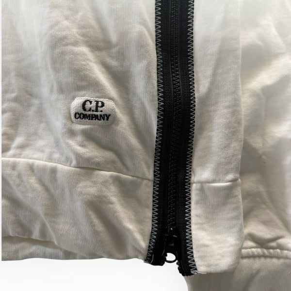 Détail du logo brodé et de la fermeture éclair noire sur un sweat blanc en coton Secondstore C.P. Company