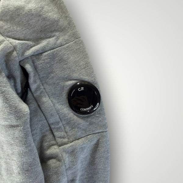 Détail de la manche grise en coton Secondstore C.P. Company avec poche zippée et lentille emblématique noire