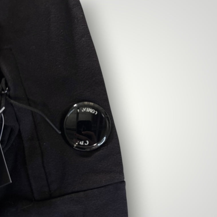 Détail de la manche noire du sweat-shirt Secondstore C.P. Company avec la lentille signature sur poche zippée