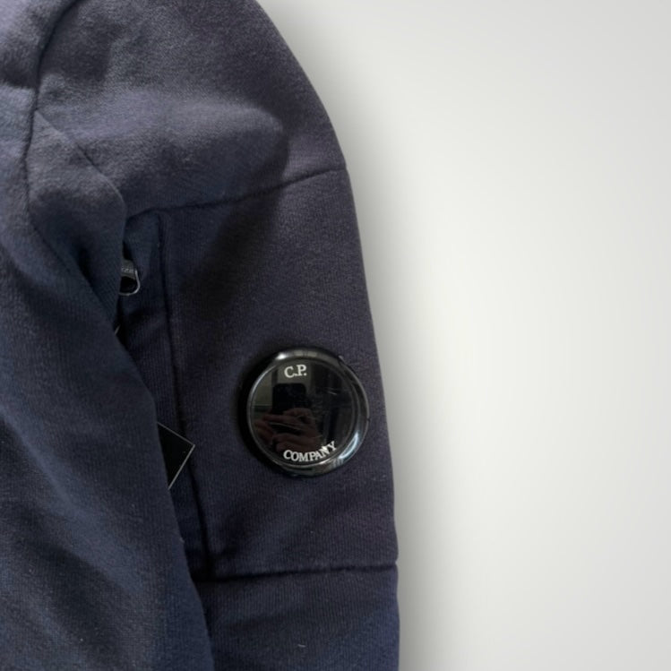 Détail de la manche noire en coton Secondstore C.P. COMPANY avec poche zippée et lentille iconique
